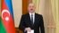 Азербайджанский лидер Ильхам Алиев опускает бюллетень в урну на избирательном участке в городе Ханкенди, 7 февраля 2024 года