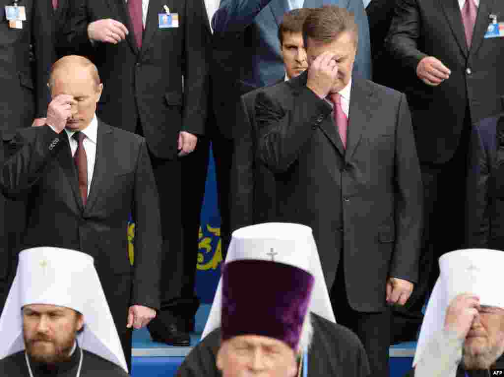 Russian President Vladimir Putin (left) and Ukrainian President Viktor Yanukovych cross themselves during a service and an official ceremony in Kyiv.