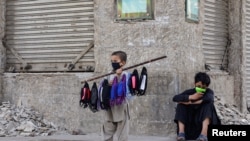 A young boy sells face masks on a stick in Karachi. 