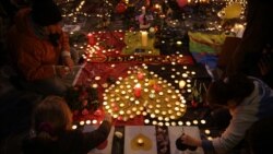 People light candles at a makeshift memorial at Brussels' Place de la Bourse.
