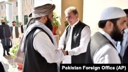 Pakistani Foreign Minister Shah Mehmood Qureshi (center) receives members of the Taliban delegation at the Foreign Office in Islamabad in October 2019. 