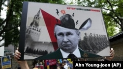 Зображення президента Росії Володимира Путіна на плакаті під час акції проти вторгнення Росії до України біля російського посольства у Південній Кореї. Сеул, 10 липня 2022 року