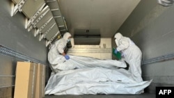 Представители Международного Красного Креста проверяют мешки с останками военнослужащих во время обмена телами, август 2024 года