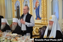 Президент Росії Володимир Путін (із мікрофоном), а праворуч від нього Московський патріарх Кирило (архівне фото)