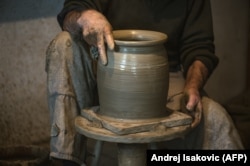 A Zlakusa potter works a piece into shape on a hand-turned wheel.