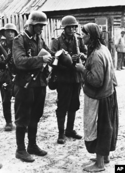 Україна. Друга світова війна. Фото агентства «Ассошіейтед прес», яке датоване 12 жовтням 1941 року, й котре підписане так: «Все, що ця українка могла запропонувати німецьким солдатам в Україні, – це глечик кислого молока, яке вони охоче прийняли»