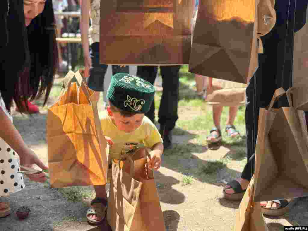 Сабый кискән бүләкне карый