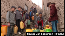 کودکان برای پر کردن بشکه های شان از نل عمومی در قطار ایستاده اند