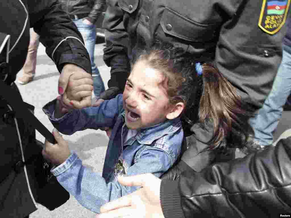 Полицијата апси девојче коешто извикува &bdquo;слобода&ldquo; во текот на протестот на опозицијата во Баку на 17 април. Девојчето и неговата мајка беа заеднички одвезени во полициско возило. 