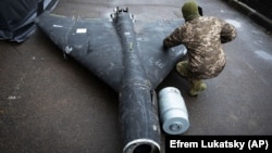 Украинский военный осматривает сбитый ранее беспилотник Shahed с термобарическим зарядом, запущенный Россией, 14 ноября 2024 года