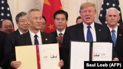 Китайският вицепремиер Лю Хъ и президентът Доналд Тръмп след подписването на споразумението