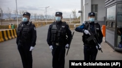 Police officers stand at the outer entrance of detention center in China's western Xinjiang region.