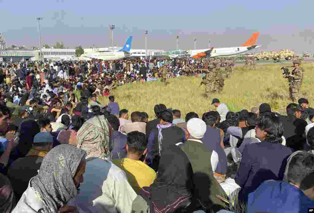 Американски войници охраняват периметъра на международното летище в Кабул, Афганистан. В понеделник американските военни и официални лица бяха съсредоточени върху летището в Кабул, където хиляди афганистанци се втурнаха по асфалта и се вкопчиха в американските военни самолети, подготвени за излитане на служители на посолството на САЩ, което затвори в неделя.