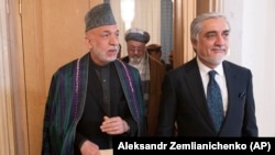 Former Afghan President Hamid Karzai (L) and head of Afghanistan's High Council for National Reconciliation Abdullah Abdullah arrive at the conference in Moscow on March 18.