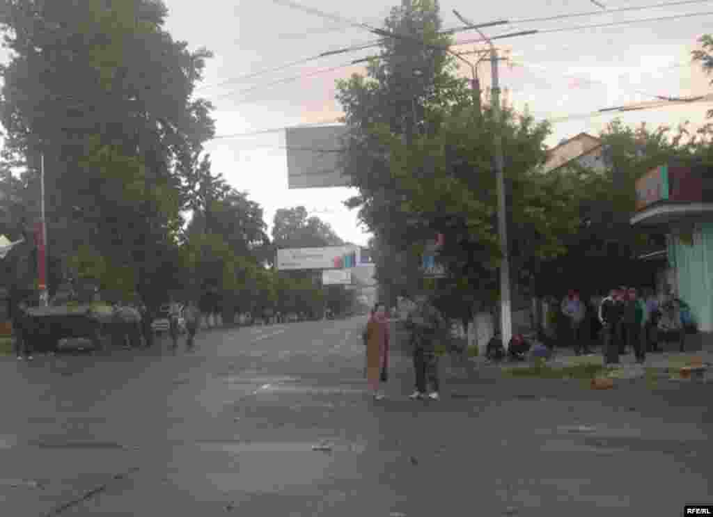 Ош шаарынын көчөлөрүнүн биринде турган милиция кызматкерлери жана шаар тургундары. 11-июнь, 2010-жыл.