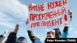 A demonstrator holds up a sign saying "We do not need an expired president!" at a rally in March 2020 in St. Petersburg.