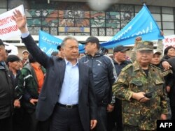 Бийликтен кулатылган Курманбек Бакиев (солдо) иниси Жаныш Бакиев (оңдо) менен апрель окуясынан кийинки митингде. Ош шаары, 15-апрель, 2010