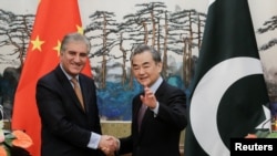 وانگ یی وزیر خارجه چین (راست) با همتای پاکستانی‌اش شاه محمود قریشی