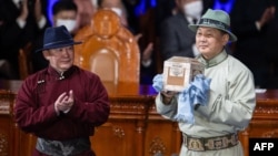 Монголиянын мурдагы президенти Халтмаагийн Баттулга жаңы шайланган президент Ухнаагийн Хурэлсухко бийликти тапшырып берүүдө.  25-июнь, 2021-жыл.