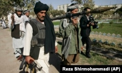 Foști luptători talibani merg să predea armele autorităților afgane din Herat, la vest de Afganistan, duminică, 31 octombrie 2010.