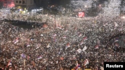 Studenții și manifestanții antiguvernamentali își aprind telefoanele mobile în timpul unui protest la Belgrad pe 15 martie.