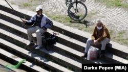 Луѓе со заштитни маски рибарат на брегот на Вардар во Скопје, пензионери