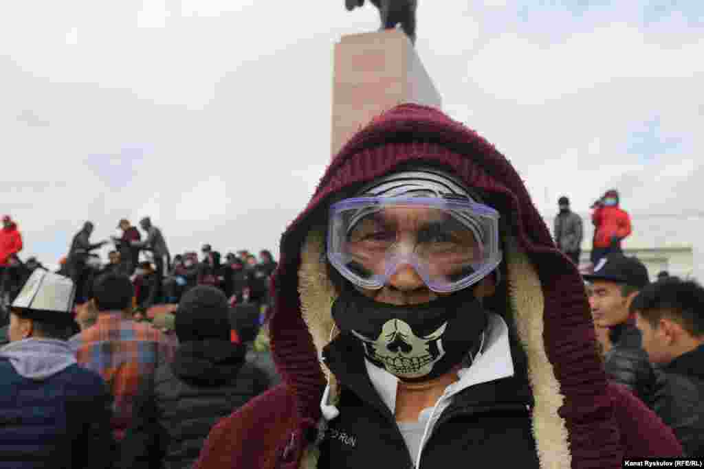 Мужчина в маске и очках на площади &laquo;Ала-Тоо&raquo;, где идет митинг.