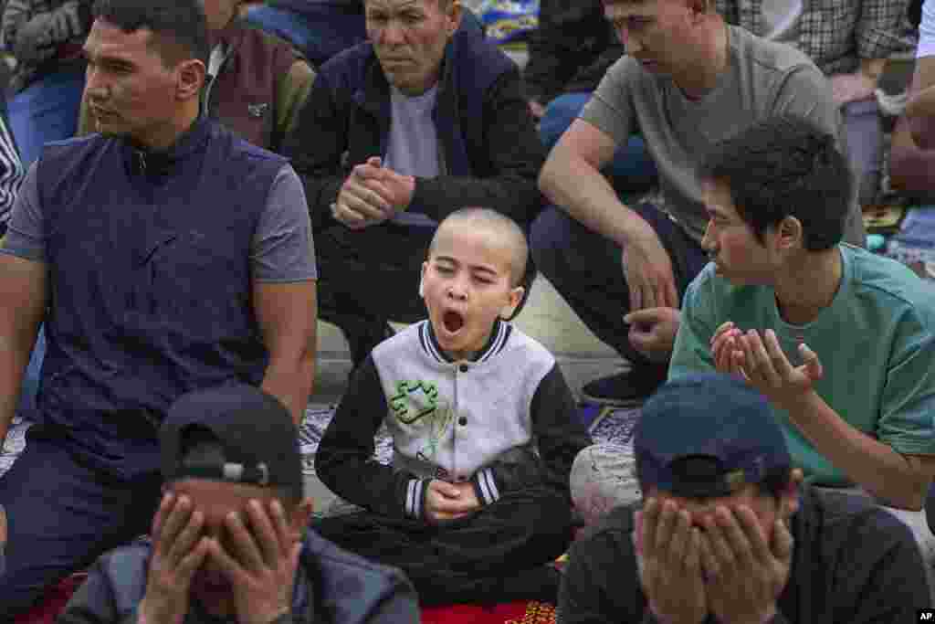 گروهی از مسلمانان در حال اقامهٔ نماز عید قربان در مسجد جامع مسکو در روز ششم ژوئن، در حالی که یک پسربچه خمیازه می‌کشد