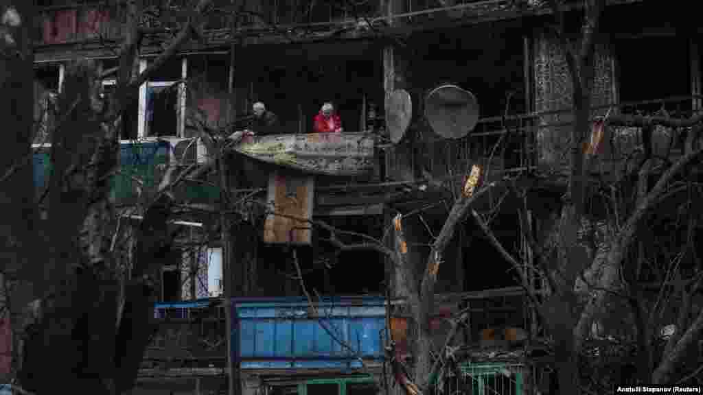 Stanovnici stoje na balkonu svog stana u zgradi oštećenoj ruskim dronovima u Kramatorsku, u Donjeckoj oblasti, 2. decembar 2025.