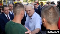 Белорускиот претседател Алeксандaр Лукашенкo разговара со вработен во фабриката за трактори во Минск, 17.08.2002 година