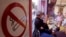 Customers smoke cigarettes next to a no smoking sticker in a bar in Marseille, December 28, 2007.