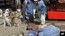 آرشیف، یک گدای زن همراه با کودکش در یک از جاده های شهر جلال آباد