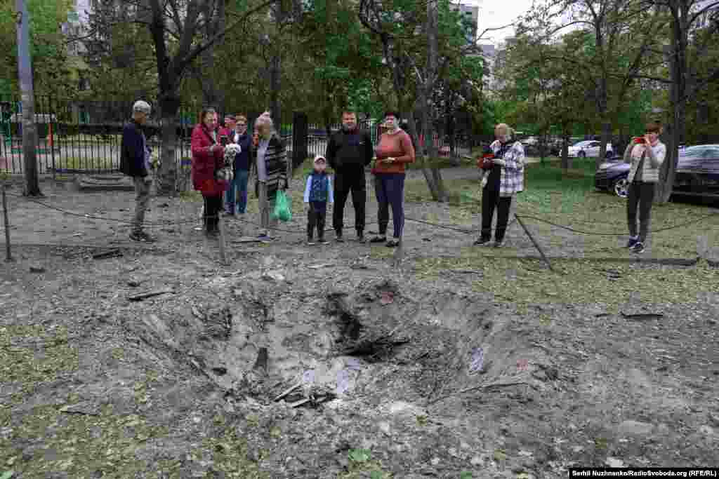 Кияни біля однієї із вирв в Оболонському районі, що виникла внаслідок удару РФ по Києву, 4 травня 2025 року