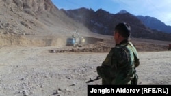 Пограничник наблюдает за строительством дороги на кыргызско-таджикской границе. Иллюстративное фото.