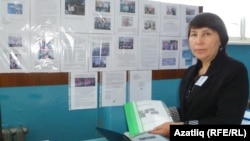Укытучы Ләйлә Чумарова “Мәктәп еллары” газетасын күрсәтә