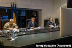 Ministrul român al Apărării, Ionuț Moșteanu (în centru) în timpul videoconferinței pe tema zidului anti-drone, coordonată de comisarul euopean pentru Apărare, Andrius Kubilius.
