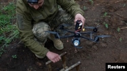 Українські військовослужбовці готують дрони FPV поблизу лінії фронту в Дніпропетровській області, 8 травня 2025 року