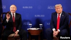 Володимир Путін (ліворуч) реагує на запитання про війну в Україні від іноземних журналістів під час церемонії фотографування з президентом США Дональдом Трампом в Анкориджі, штат Аляска, 15 серпня 2025 року