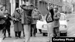 Doi protestatari de la Timișoara sunt chestionați de forțele de ordine în timpul manifestărilor din decemmbrie 1989.