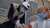 A health worker gets the blood sample of a person during door-to-door testing and screening campaign in Islamabad on June 15.
