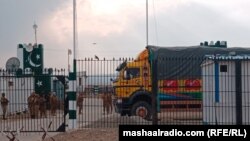 په انګور اډه کې یو مال لېږدوونکی ګاډی افغانستان ته د اوښتو لپاره انتظار باسي، ورسره د پاکستان امنیتي سرتېري هم پهره کوي - د مارچ نهمې انځور. 