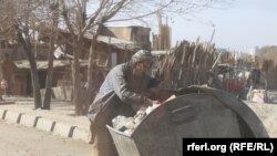 یک معتاد در حال جمع آوری اشیای آهنی و پلاستیکی از یکی از کثافت دانی ها در شهر کابل.