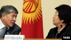Мурдагы президент Роза Отунбаева жана азыркы президент, Убактылуу өкмөттүн учурунда премьер-министрлик кызматты аркалаган Алмазбек Атамбаев өкмөттүн Бишкектеги жыйынында, 20-декабрь, 2010-жыл.
