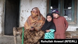 Reza Gul with her granddaughter Salima (center) whose father was killed five years ago.