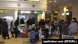 Пассажиры у стойки регистрации на рейс авиакомпании "Туркменские авиалинии" в московском аэропорту Домодедово.