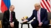 Președintele american Donald Trump (dreapta) gesticulează în timpul unei întâlniri cu președintele rus Vladimir Putin la un summit al liderilor G20 în iunie 2019.