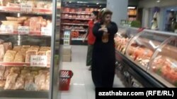 Aşgabadyň söwda marketleriniň birinde et bölümindäki önümlere seredýän ýaşaýjylar (Arhiw suraty)