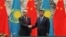 Chinese President Xi Jinping (right) shakes hands with Kazakh President Qasym-Zhomart Toqaev at the end of a signing ceremony at the Great Hall of the People in Beijing on September 11, 2019.