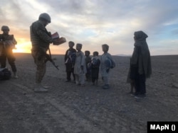 Soldați români dau cadouri copiilor afgani