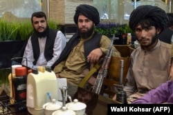 Taliban fighters wait for their lunch to be served at a restaurant in Kabul.